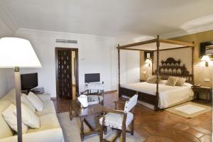 a bedroom with a large bed and a couch at Parador de Siguenza in Sigüenza