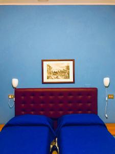 una camera blu con letto con testiera rossa di Hotel Sesto a Sesto San Giovanni