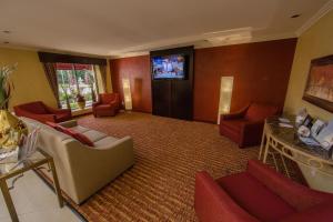 a hotel lobby with chairs and a tv on the wall at Ramada by Wyndham Houston Intercontinental Airport East in Humble