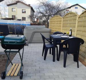 a grill and a table and chairs on a patio at Apartments with outdoor SPA jacuzzi and sauna in Vilnius