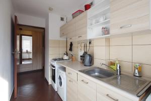 a kitchen with a sink and a washing machine at Apartament RSL in Ruda Śląska