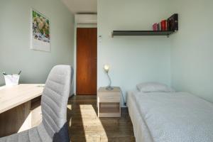 a bedroom with a bed and a desk and chairs at Apartament RSL in Ruda Śląska