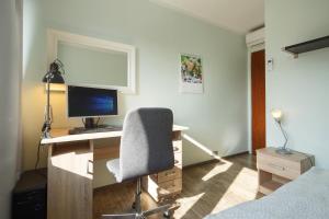 Cette chambre comprend un bureau avec un ordinateur et une chaise. dans l'établissement Apartament RSL, à Ruda Śląska