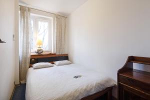 a small bedroom with a bed and a window at Apartament RSL in Ruda Śląska