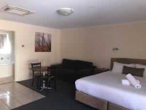 a hotel room with a bed, chair and a television at Clare Central in Clare