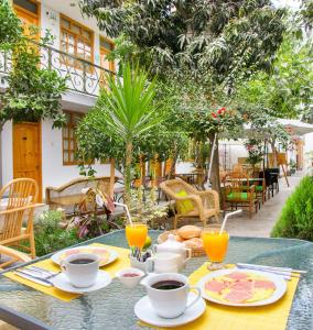 una mesa con tazas y platos de comida. en El Huerto Hostel en Ica