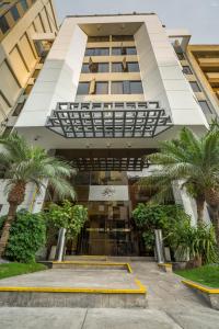 a building with palm trees in front of it at Jose Antonio Executive in Lima