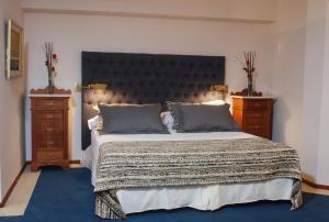 a bedroom with a large bed and two night stands at Hotel de la Cañada in Córdoba
