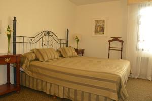 a bedroom with a bed and a window and a window at Hotel de la Cañada in Córdoba