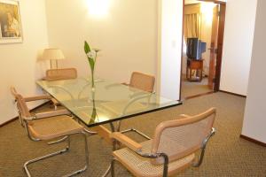 a glass table with chairs and a vase with a flower on it at Hotel de la Cañada in Córdoba