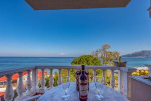 a table with two wine glasses on a balcony at Saltwater Serenade Apartments in Zakynthos