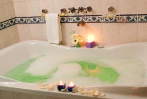 a bath tub with candles in it with candles at Hotel de la Cañada in Córdoba