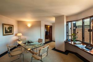 a room with a glass table and chairs and a window at Hotel de la Cañada in Córdoba