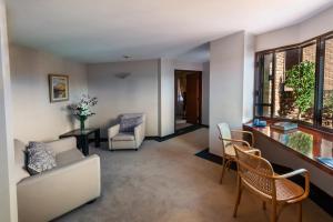 a living room with a couch and chairs and a window at Hotel de la Cañada in Córdoba