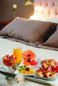 a tray with a plate of food and a glass of orange juice at Hotel de la Cañada in Córdoba
