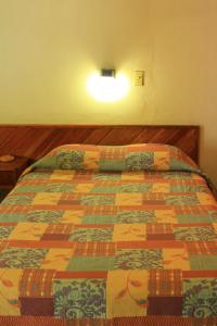 1 dormitorio con 1 cama con colcha colorida en Hotel Avenida, en Acapulco