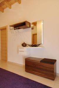 Schlafzimmer mit einem Bett, einem Spiegel und einem lila Teppich in der Unterkunft Gästehaus Weber in Oberperfuss