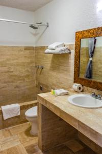 a bathroom with a sink and a toilet and a mirror at Hotel Green 16 in Cancún +99 photos