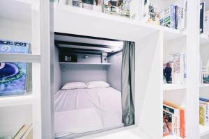 大阪的住宿－BOOK AND BED TOKYO Shinsaibashi，书架上的一张白色小双层床