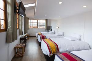 Giường trong phòng chung tại MOAF Cusco Boutique Hotel