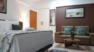 a hotel room with a bed and a couch at B & A Suites Inn Hotel - Quarto Luxo Gold in Anápolis