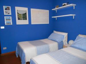 two beds in a room with blue walls at B&B Come A Casa in Cerrione