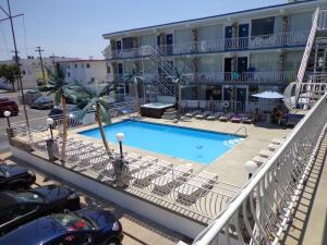 a swimming pool in front of a building at Quarterdeck Motel in Wildwood