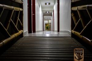 an empty corridor in a building with benches at Hotel la Embajada Antioqueña in Cúcuta