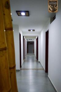a hallway with white walls and a long hallway with white floors at Hotel la Embajada Antioqueña in Cúcuta