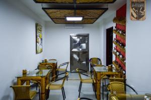 a dining room with tables and chairs and a door at Hotel la Embajada Antioqueña in Cúcuta