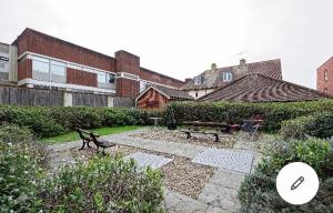 a garden with a bird statue in front of a building at Copperfield Apartment in Canterbury