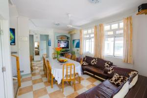 a living room with a table and a couch at Bella Guesthouse Charming Beachfront Stay in Blue Bay
