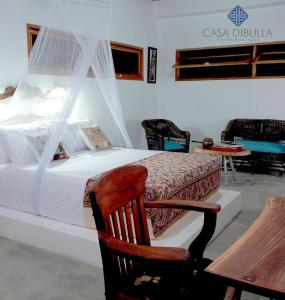 a bedroom with a bed and a chair and a piano at Casa Dibulla Hotel Boutique in Dibulla