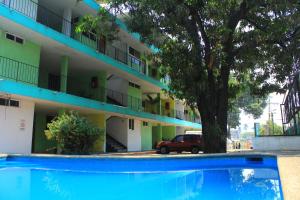 a blue swimming pool in front of a building at Hotel Avenida in Acapulco