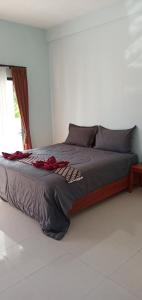 a large bed in a bedroom with a window at Honeybee Homestay in Kuta Lombok