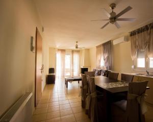 uma sala de jantar com uma mesa e cadeiras e uma ventoinha de tecto em Keramoti Luxury Apartments em Keramoti