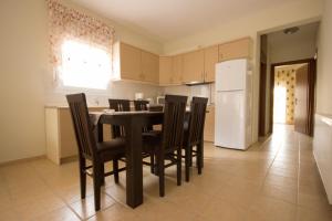 a kitchen with a table and chairs and a refrigerator at Stasa Luxury Apartments in Keramoti