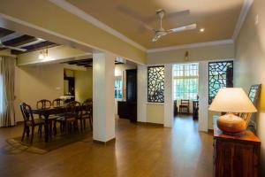 a dining room and living room with a table and chairs at Alencherry plantation homestay in Thekkady