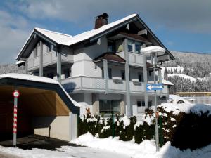 ein Haus mit Schnee auf dem Boden davor in der Unterkunft Appartement Pürstinger in Altenmarkt im Pongau