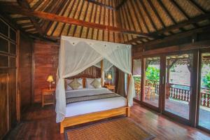 een slaapkamer met een hemelbed in een resort bij Ari Cottages Ubud in Ubud