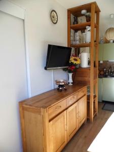 ラ・ノルマにあるappartement tous confortのキッチン(木製キャビネット上のテレビ)
