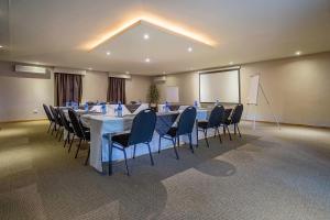 a conference room with a long table and chairs at Three Oaks and an Aloe Boutique Hotel in Hartbeespoort +33 photos