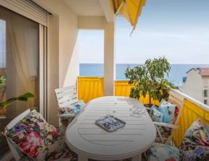 a white table and chairs on a balcony with the ocean at Stunning 2 bed Flat Nice front of the beach Seaview in Nice