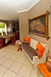 een woonkamer met een bank met oranje kussens erop bij Tranquil Shores in Wilderness