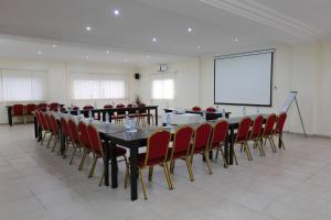 a conference room with a table and chairs and a screen at Hotel Palm Beach in Pointe-Noire