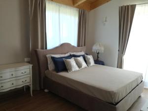 Schlafzimmer mit einem Bett mit blauen und weißen Kissen in der Unterkunft B&B CasalFarano in Cupra Marittima