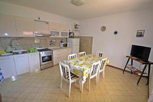 a kitchen with a table and chairs and a kitchen with a stove at Sonja-Dajla Apartments in Dajla