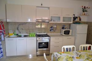 a kitchen with white cabinets and a stove top oven at Sonja-Dajla Apartments in Dajla