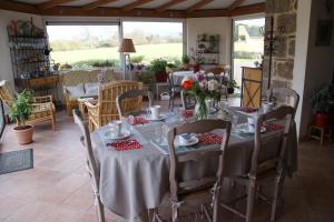 a dining room with a table with flowers on it at La Kerandière in Tonquédec