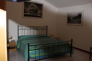a bedroom with a bed with a green comforter at Appartamento Cielo in Costermano
